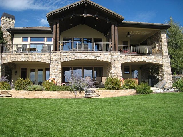 The southern exposure of a lake house with glass windows lining the exterior is shown.